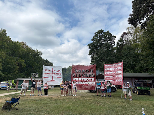 Demonstrators outside of the Judicial Picnic holding and displaying large banners.
